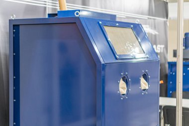 Fabrika ortamında mavi endüstriyel makine, kontrollü dijital ekran, yapay ışıklandırma, nötr arkaplan, kısmen gizlenmiş başka bir makine, mevcut insan yok