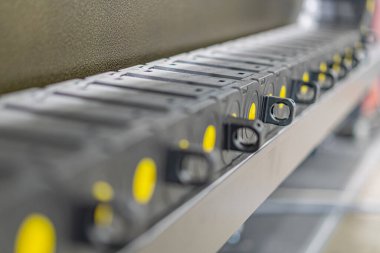 Aydınlatma altında bile sarı-bileşenli elektronik cihazlar içeren sanayi veya laboratuvar ayarları, metin yok.
