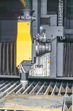 Endüstriyel bir ayar, taşıyıcı sistem üzerinde robotik bir kol, sarı bir alet eklentisi endüstriyel makineler, çoklu hareket eksenleri, parlak yapay ışıklandırma ve metalik