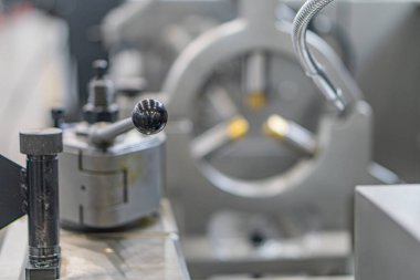 Makine ile endüstri sahnesi, dönen metal bir nesneye odaklan torna veya değirmen makinesinin bir mili üzerinde arka plan mekanik parçaları ve yapıları suni aydınlatma ayarında gösterir