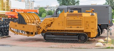 Asfaltlı alanda sarı buldozer, tuğla desenli ön plan, geniş bıçak, izler, kontroller, kollar, endüstriyel ayar, vinç, parçalı bulutlu gökyüzü, bulutlu gün, zemin seviyesi perspektif