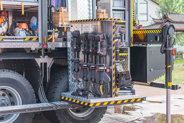 Su ve benzin için etiketlenmiş, açık bir yerleşim alanına park edilmiş, faydacı, koyu renkli kamyonun yakın plan görüntüsü yağmurlu ve nemli olduğunu gösteriyor.