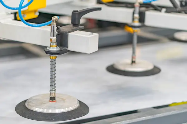 Endüstriyel bir ortamın yakın görüntüsü, muhtemelen bir üretim ya da montaj alanı. Merkezli diske benzeyen iki yuvarlak nesne mevcut, birinin vidası yerleştirilmiş metalik mekanizmayı gösteriyor.