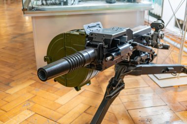 Cam duvarlı bir sergi veya müze alanında tekerlekli platformda bulunan çok namlulu uçaksavar silahının kapalı alanda sergilenmesi. Silah iki operatör için kontrollü ve belirgin bir şekilde kullanılmadan sergileniyor. a