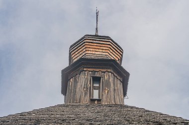 Huzurlu bir Orta Avrupa köyünde, eski ahşap Ortodoks kilise kulesi yumuşak gökyüzüne karşı sönük renkler, görünür bir yazı ya da ayırt edici bir işaret yok.