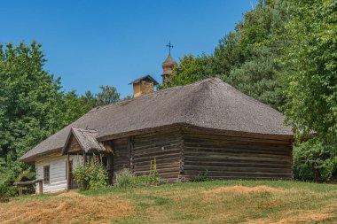Orta Avrupa 'da eski bir köyde, çimenli bir yamaçta kır kulübesi, modern bir uzantısı, açık kapısı, ve iyi basılmış yolu, berrak mavi gökyüzü, sakin atmosfer, doğal aydınlatma