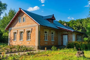 Antik kırmızı tuğla, iki katlı mesken, balkon, kiremit çatı, çoklu pencereler, kırsal banliyö manzarası, parçalı bulutlu gökyüzü, natüralist fotoğraf, açılı perspektif, sabahın erken saatlerinde ya da