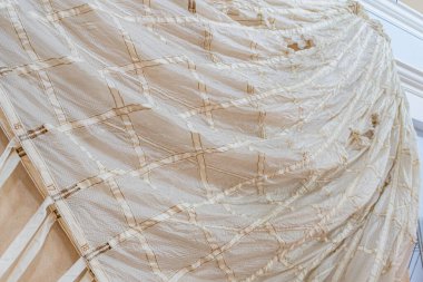 Bir ışık yakın plan, desenli paraşüt bileşeni karmaşık desenler ve organik şekil bir sergi veya depolama altında nötr bir arkaplan karşı görüntülenir alan sığ derinlik vurgu