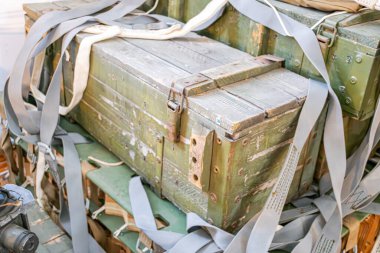 İçinde bant ve aşınma izleri olan askeri mühimmat kutuları dağınık metal parçalar, kumaş ya da tuval. a