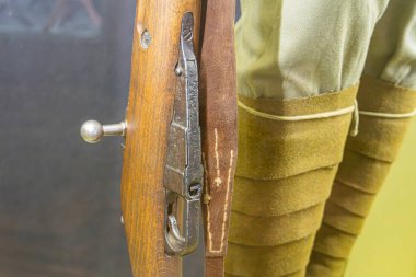 Antika sürgülü tüfek, klasik askeri üniforma, kapalı alan yeşilimsi renk, bulanık arka plan, yakın plan, ahşap ve metal doku, işçiliğin altını çizmek.