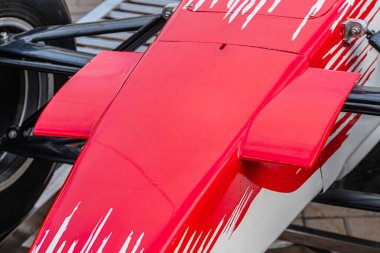 Formula 1 ön kanat montajının yakın plan görüntüsü, ağırlıklı olarak beyaz ve kırmızı aksanlı, aerodinamik özellikleri aerodinamik olarak gösteren,