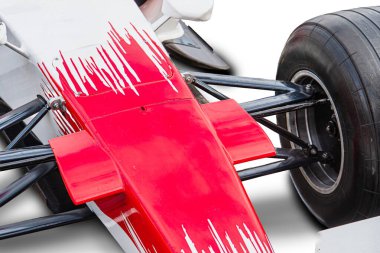Formula 1 'e yakın çekim, ağırlıklı olarak beyaz, kırmızı ve siyah aksanlı, açık hava ışığı altında aerodinamik bileşenler sergiliyor.