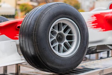 Formula 1 arabası ön sağ tekeri kayıp, tekerlek merkezi ve süspansiyon bileşenlerini gösteriyor beyaz aksanlı kırmızı araç ve UPS sponsorluk markası ayarları bakım alanı veya pit stop öneriyor