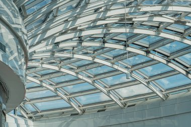 Modern, kapalı alan eğimli cam tavanı, dağınık gün ışığı, endüstriyel tasarım, cilalanmış beton döşeme, minimalist stil