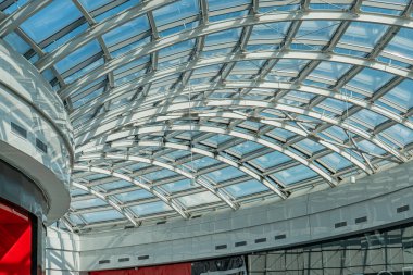 Kapalı alan, kubbeli cam tavan, parlak atmosfer, doğal ışık nedeniyle. Çelişkili renklerde merkezi kırmızı yapı. Modern, minimalist tarz.