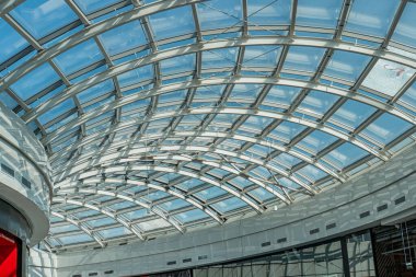 Kıvrımlı kubbe tavanı, düzensiz tavan pencereleri, beyaz duvarlar, boş ama davetkar atmosfer, modern mimari tarzı, geniş doğal ışık