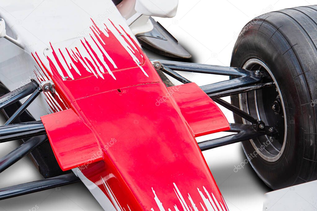 Close-up of a Formula One car, predominantly white with red and black accents, showcasing aerodynamic components under soft outdoor light