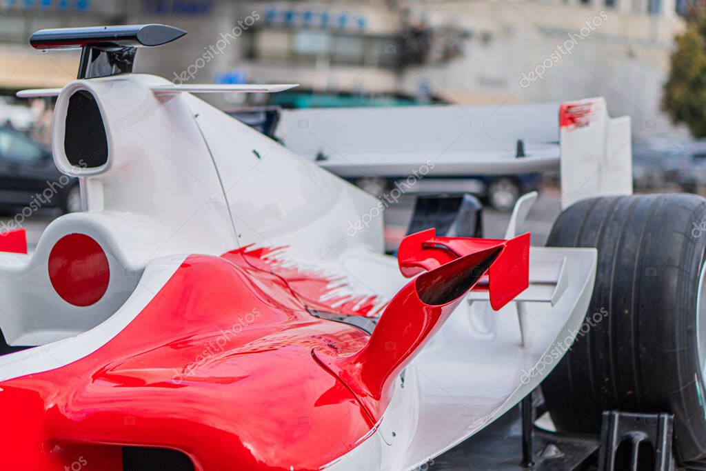 Red Formula 1 car displayed outdoors, likely at an event or exhibition Angled view showcases aerodynamic design and engineering components Predominantly red with white accents and sponsor logos Na