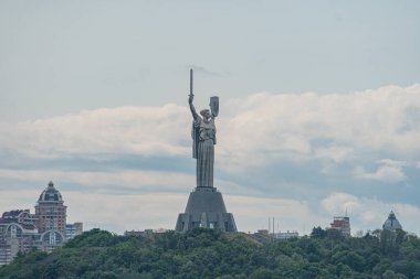 Aydınlanmayı veya özgürlüğü simgeleyen anıtsal bir heykel, mimari çeşitliliğe sahip Kiev şehir zeminine karşı dimdik ayakta duruyor heykel, elinde meşale, i Kyiv, Ukrayna 06-14-2025