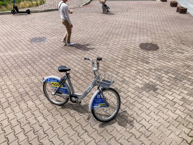 Ukrayna 'nın Kyiv şehrinin mavi, zıt tuğla sokağında durgun bir bisiklet kiralanır. Kalabalık şehir manzarası arasında Kyiv, Ukrayna 07-01-2025