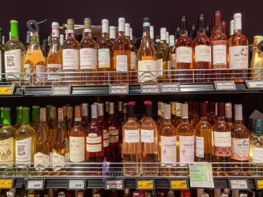 Şarap dükkanı vitrini, çeşitli renkli şişeler ve etiketlerle dolu şarap rafı Kyiv, Ukrayna 07-12-2025