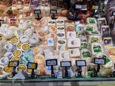 Siyah raflarda çeşitli peynirlerin sergilendiği canlı peynir tezgahı, Whit Kyiv, Ukrayna 07-10-2025 arasında değişen dokuları ve renkleri ön plana çıkarıyor