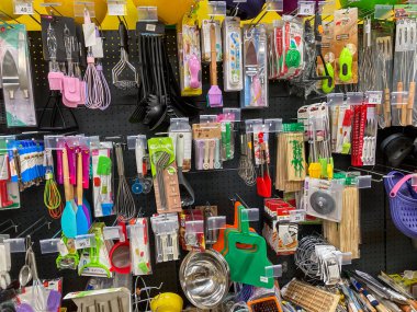 Değişik yemek aletleri, ahşap kaşıklar, Kyiv, Ukrayna 07-13-2025 'e karşı açık kancalarda sergilenen silikon spatulaları olan canlı, düzenli bir mutfak gereçleri mağazasının genel bakış açısı