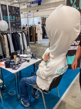 Beyaz kapüşonlu, laptoplu, kağıtlı, beyaz tavanlı, açık kirişli kapalı mekan ayarlı, parlak hatta aydınlık, gizli ahşap Kyiv, Ukrayna 07-31-2025