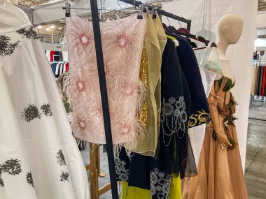 Karmaşık süslenmiş elbiseler koleksiyonu, suni aydınlatma ile kapalı alanda sergilenen pembeler, sarılar, siyahlar, beyazlar ayrıntılı tasarımlar Kyiv, Ukrayna 07-31-2025