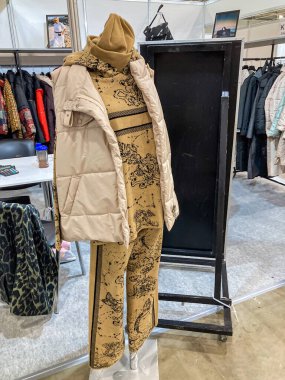 Manken desenli pantolon ve palto sergileniyor. Giysi sergisinin bir parçası. Yapay mağaza zeminine karşı düzenlenmiş.
