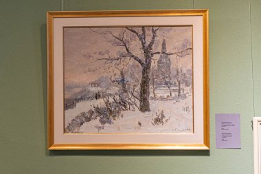 Kiev 'in klasik Noel manzarası, ağaçlar ve bir yapıyla karlı bir manzara, bir sergide asılı, bir duvara yaslanmış, yakınlardaki bilgi etiketi, m Kyiv, Ukrayna 12-24-2023