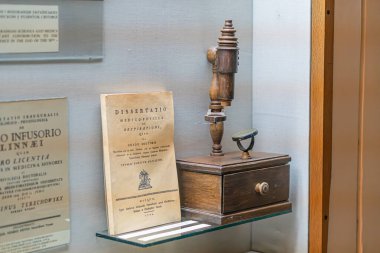 Antika mikroskop, metal silindir ve ahşap göğüs, yazılı kağıt, nötr iç mekan, yapay ışıklandırma, açılı perspektif, gizli tarz, h Kyiv, Ukrayna 12-24-2023