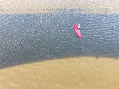 Kırmızı bir raket üzerinde siyah giysili bir raket ustalıkla nehirde ilerler. Hafif dalgalar bırakır. Işıklar sahneye derinlik katar, uzaklardan ya da yüksekten yakalanır.
