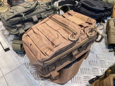 Kapalı alandaki zeytin yeşili sırt çantası, keseler, fayanslı zemine yerleştirilmiş koruyucu başlık yapay ışıklandırmanın altında Ukrayna askeri taktik teçhizatı görüntüsü