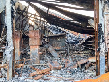 Mahvolmuş iç mekan, felaket sonrası sahne, doğal ışıklandırma, sessiz toprak tonları, molozlar ve molozlar, ciddi hasarlı duvarlar, paslı yapısal unsurlar, açık kapı ya da pencere, gerçekten insan varlığı yok.