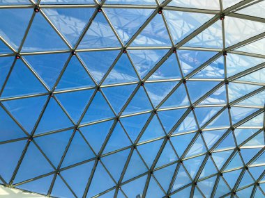 Gün ışığına yakın, saydam panellerle kaplı kubbeli tavan, mavimsi renk özellikleri, sayısız ayrı çerçeve tarafından oluşturulan karmaşık geometrik desenler. Doğal ışık kaynağı yukarıda değil.