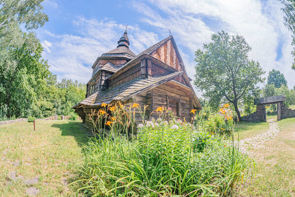 Древняя среднеевропейская деревянная православная церковь в сельской местности, изображенная как бревенчатая хижина с несколькими соломенными крышами
