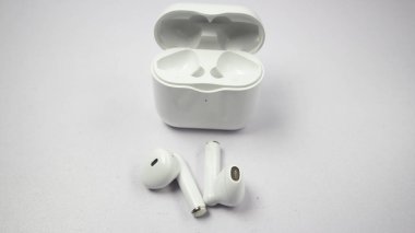 Beyaz kablosuz kulaklık veya kulaklık ve şarj çantası beyaz arkaplanda izole.