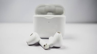Beyaz kablosuz kulaklık veya kulaklık ve şarj çantası beyaz arkaplanda izole.
