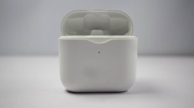 Beyaz kablosuz kulaklık veya kulaklık ve şarj çantası beyaz arkaplanda izole.