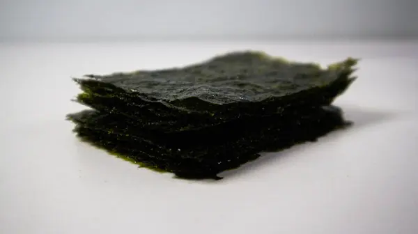 Beyaz arka planda gevrek yosun. Japon kuru deniz yosunları.