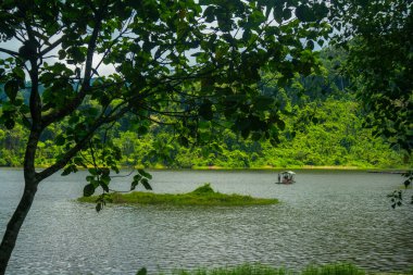 Situ gunung lake in indonesia. Forest lake under cloudy sky clipart