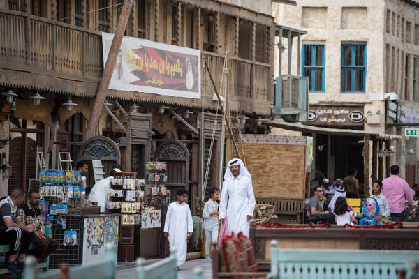 Doha, Qatar- March 05, 2019 : The Qatari family in traditional attire hang out in old bazaar market Souk Waqif.