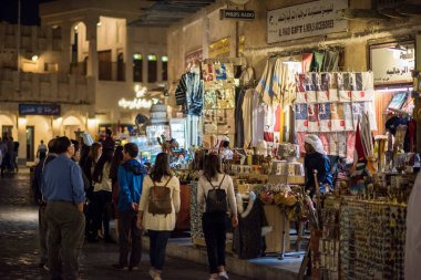 Doha, Katar - Mart 05.2022: Turistler Souq Wakif 'teki hediyelik eşya dükkanına bakıyorlar. 