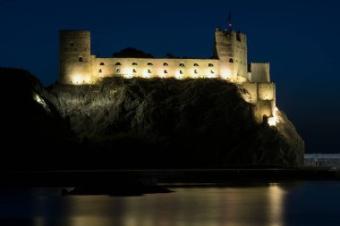 Muscat, Umman - 05 Mart 2019: Eski Muttrah kasabasında gün doğumunda Al Jalali kalesinin manzarası.