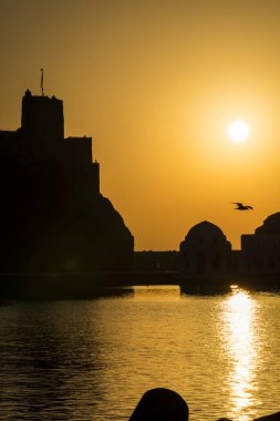 Muscat, Umman - 05 Mart 2019: Eski Muttrah kasabasında gün doğumunda Al Jalali kalesinin manzarası.