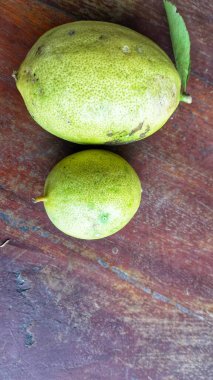 Yeşil yapraklı olgun limon meyvesi. Yeşil yapraklı limon meyvesi. Doğal limon meyvesi havada asılı durur. Taze sarı olgun limonlar.