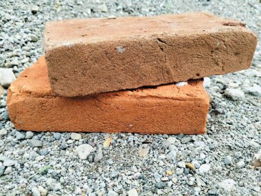 İnşaat için kullanılan katı kil tuğlalar, eski kırmızı tuğla, monokromatik arkaplan yapı temelinde tek bir kırmızı tuğla, pürüzsüz bir dokusu ve net olarak tanımlanmış kenarları var.