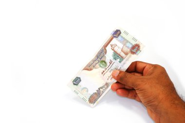 BAE para birimi notu beyaz arkaplan yakın plan görünümünde el ele tutuşuyor 