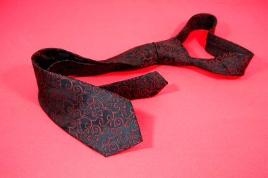 Çiçek desenli klasik kravat kırmızı arkaplanda izole edilmiş. 